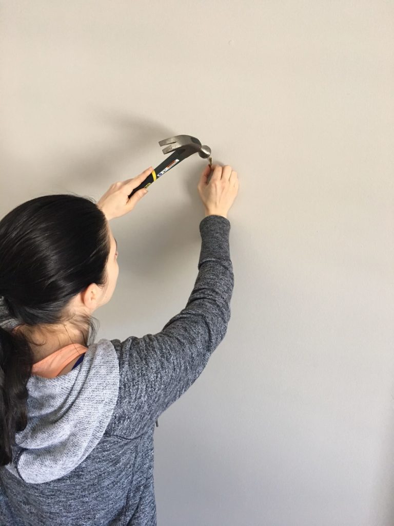 Lindsey Putzier hammering Escutcheon pin to hang artwork Lindsey Putzier Design Studio Ohio