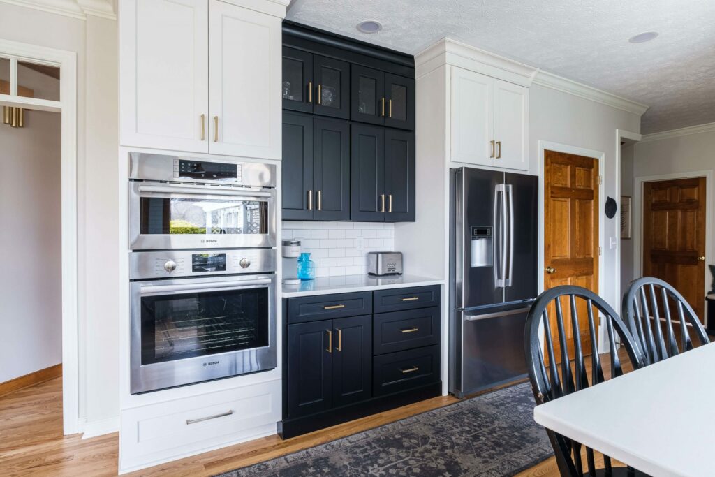 Black and white cabinetry in kitchen with wood stained door Lindsey Putzier Design Studio