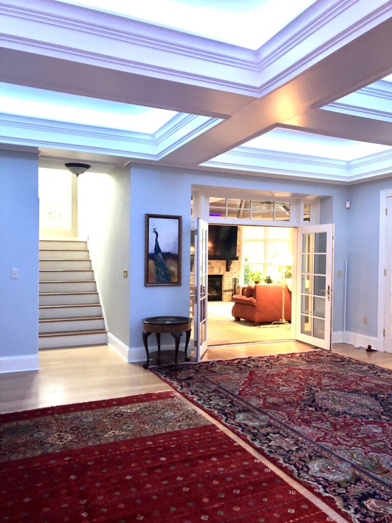 Progress image with red rugs, coffered ceiling, and LED chain lights Lindsey Putzier Design Studio