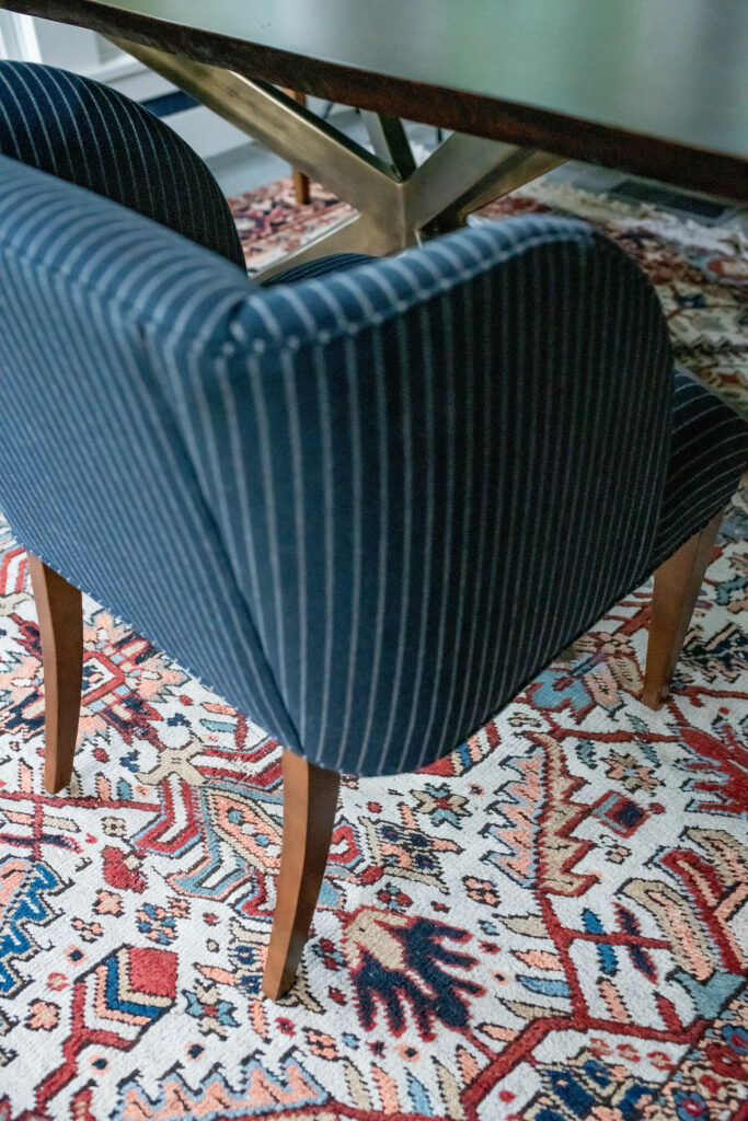 Authentic vintage rug, ;blue upholstered chairs, and metal base table in Sunroom Lindsey Putzier