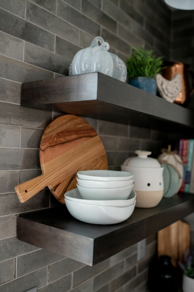 Gray tiled walls in Kitchen design with dark wooden shelves with Kitchen accessories Lindsey Putzier Design Studio Hudson, OH