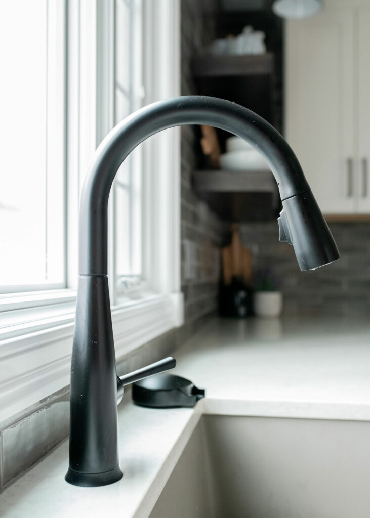Black Kitchen faucet on white countertops in Kitchen design. Lindsey Putzier Design Studio Hudson, OH