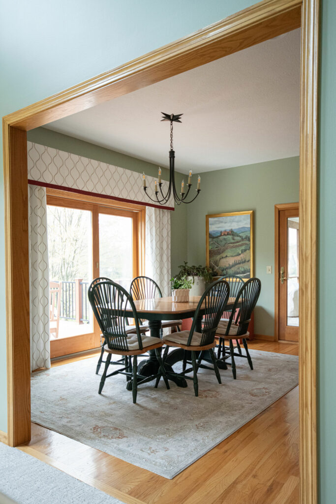 Light green walls, custom window treatment, new art and rug in Dining Room design Lindsey Putzier Design Studio Hudson, OH