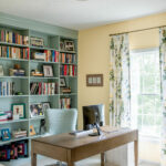 Office design with yellow walls, light blue bookshelves and office chair. Lindsey Putzier Design Studio. Hudson, OH