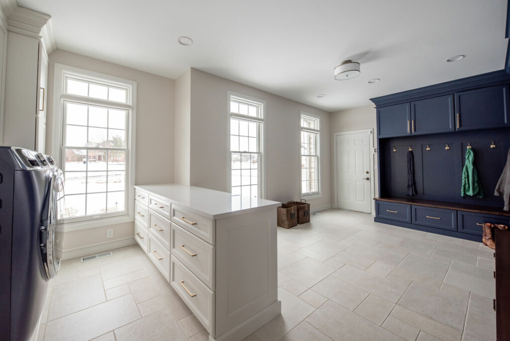 View of open spaced Mudroom with white and blue cabinets. Lindsey Putzier Design Studio. Hudson, OH