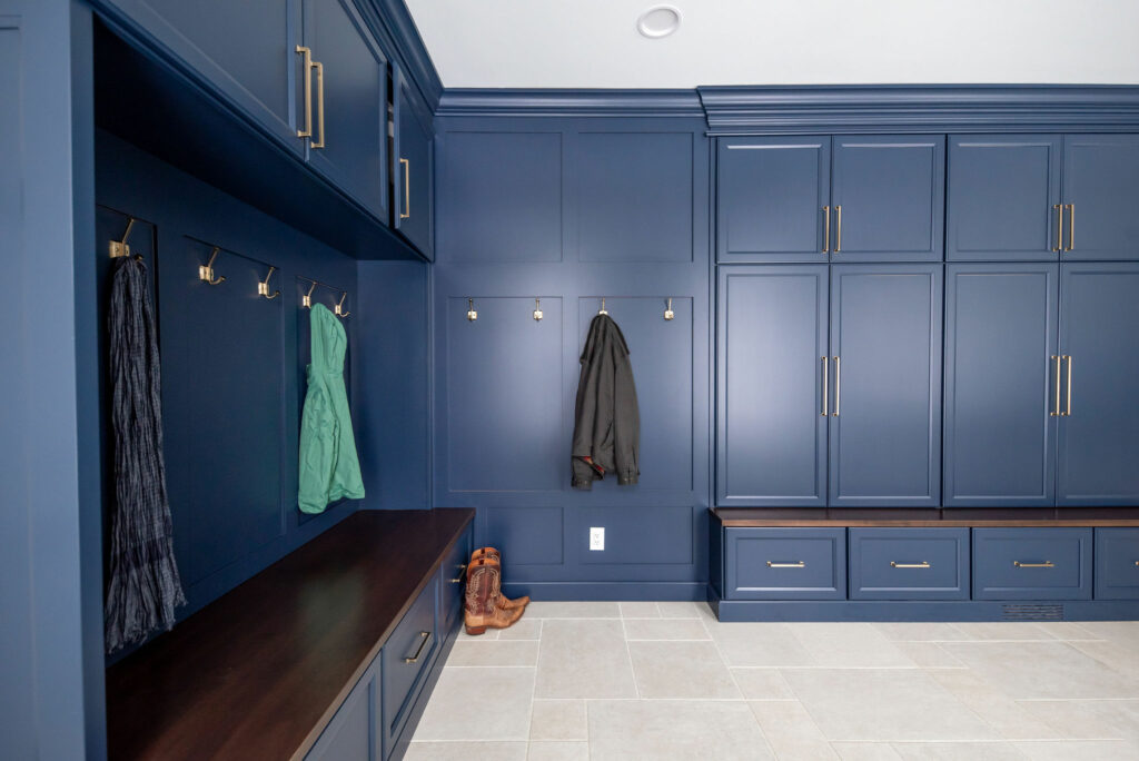 Blue cabinetry, bench, and coat storage in Mudroom design. Lindsey Putzier Design Studio. Hudson, OH