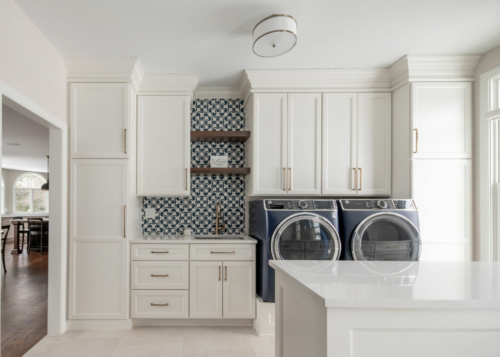 After image of Mudroom design with white cabinets, black and white backsplash, and blue washer/dryer. Lindsey Putzier Design Studio. Hudson, OH