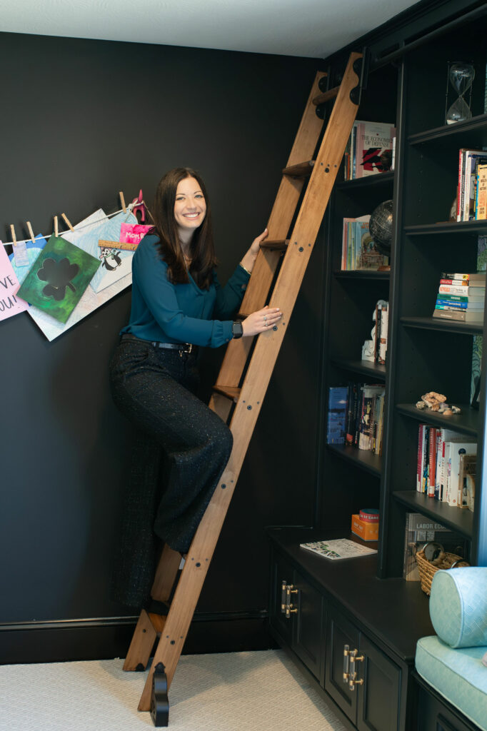 Rolling ladder attached to built-in shelves in Office design. Lindsey Putzier Design Studio. Hudson, OH