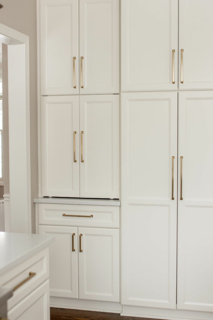 White cabinetry storage with coffee bar and fridge in Kitchen design. Lindsey Putzier Design Studio Hudson, OH