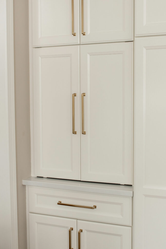 White cabinetry storage with coffee bar and fridge in Kitchen design. Lindsey Putzier Design Studio Hudson, OH