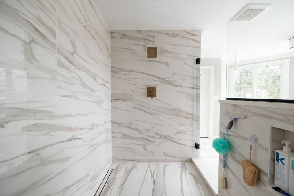 Large scaled tile in shower of Primary Bath design. Lindsey Putzier Design Studio Hudson, OH