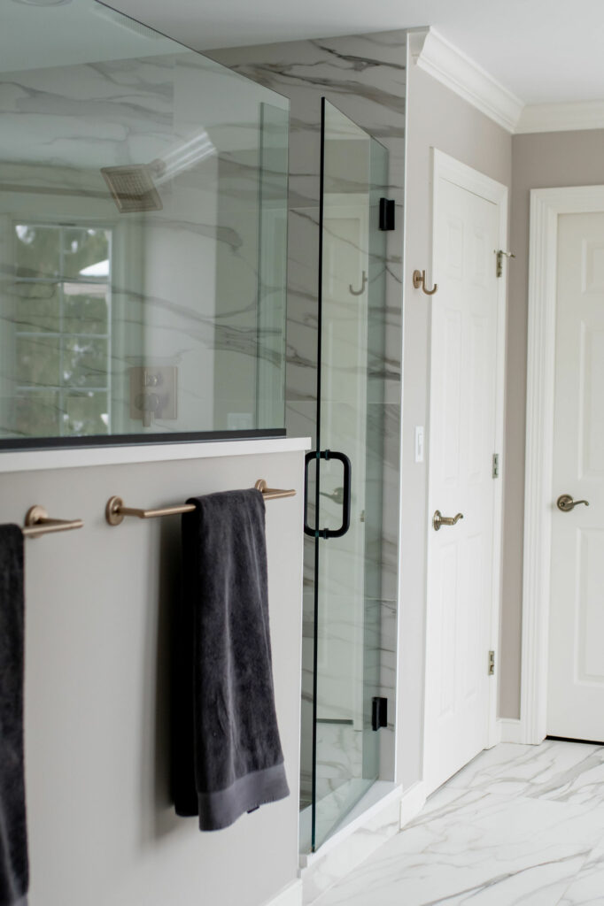 Glass door into updated shower area in Primary Bathroom design. Lindsey Putzier Design Studio Hudson, OH