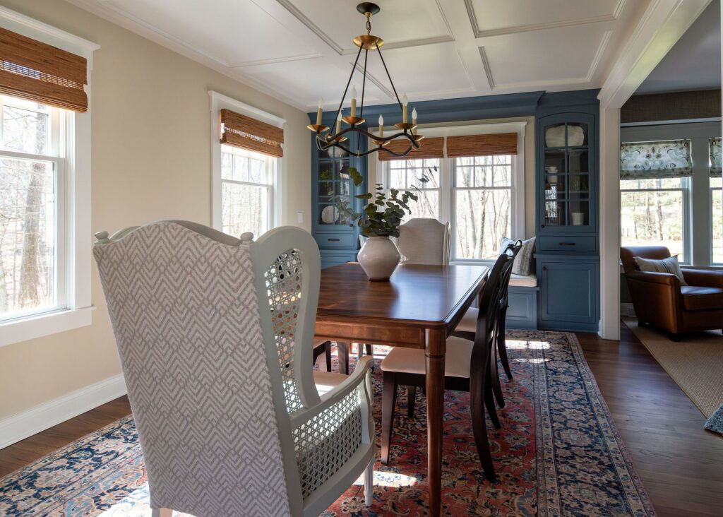 Angle looking into a dining room, looking at the table and the bay window. The bay window has built in cabinets and drawers around them. Lindsey Putzier Design Studio, Hudson, Ohio