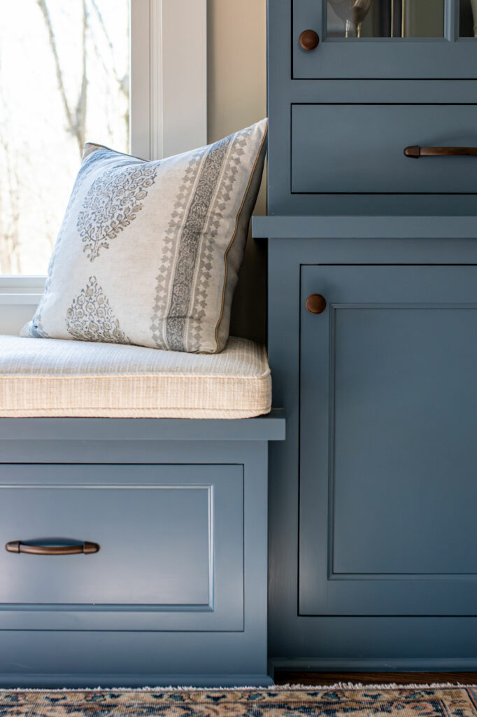 Close up view of the built-in cabinets and bench seat painted blue. Lindsey Putzier Design Studio, Hudson, Ohio