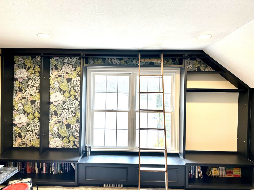 In progress photos of wallpaper installation for the back wall of built-in bookshelves. Lindsey Putzier Design Studio. Hudson, OH