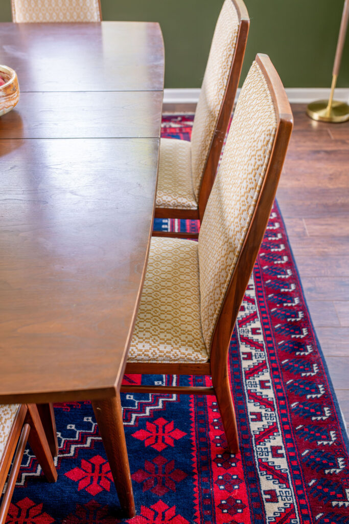 colorful patterned rug with large 6 person wooden dining room table. Lindsey Putzier interior design Hudson Ohio