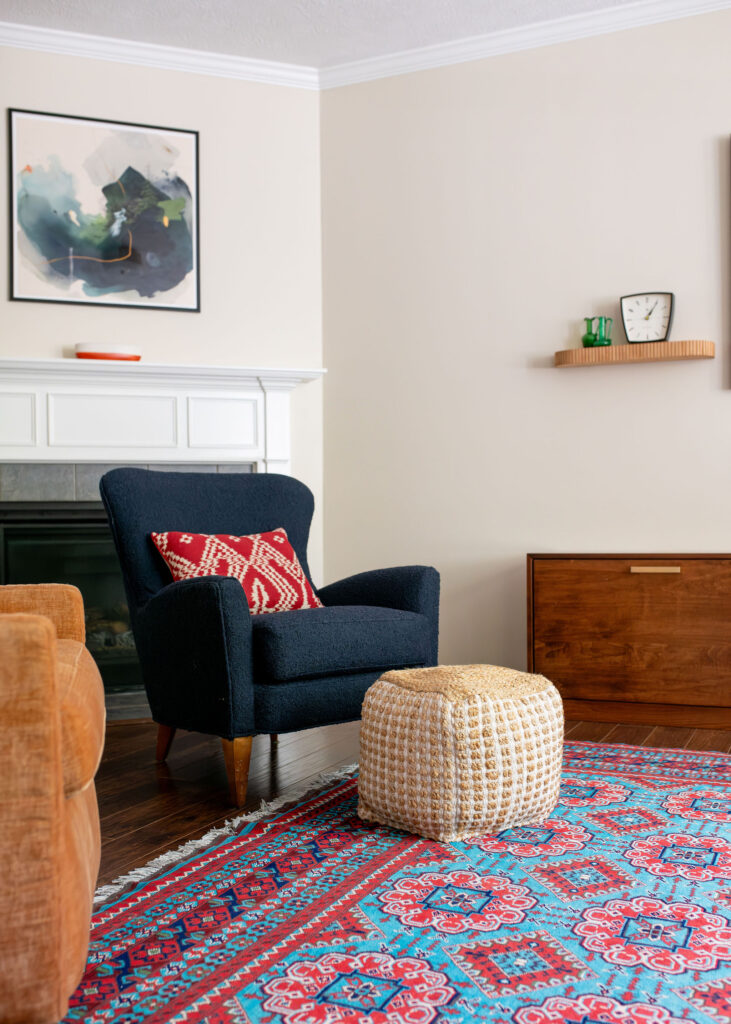 Dark blue performance fabric covered armchair and cream ottoman with patterned pillow. Hudson Ohio Lindsey Putzier 
