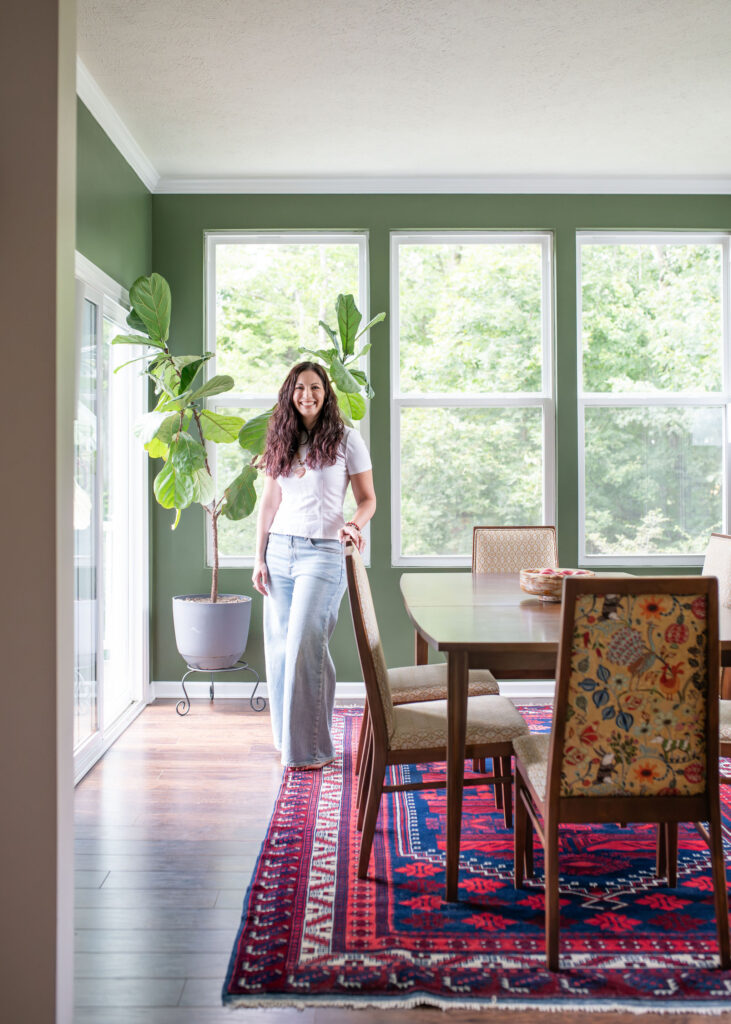 Lindsey Putzier, owner and principal designer, standing in the updated dining room with vintage table and chairs. Hudson Ohio interior design. 
