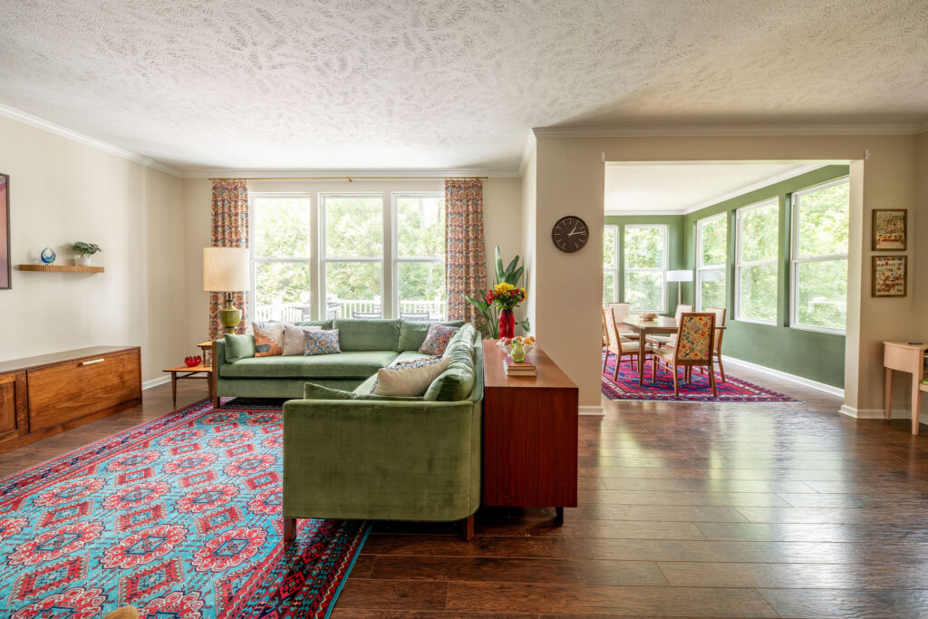After of the living room and dining room, with rich textures and patterns, vintage furniture, and custom drapery. Hudson Ohio interior design Lindsey Putzier 