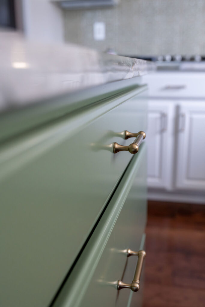 Sage green island in the kitchen with green accented marble countertops. Lindsey Putzier interior design Hudson Ohio