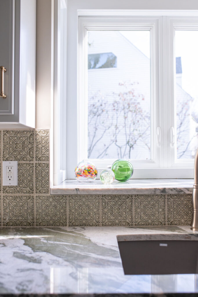 Green stone countertops with green textured backsplash tile in the kitchen. Lindsey Putzier interior design Hudson Ohio
