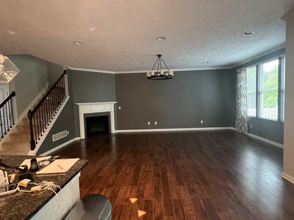 Before of the living room with dark walls and hardwood flooring.Hudson Ohio interior design Lindsey Putzier 