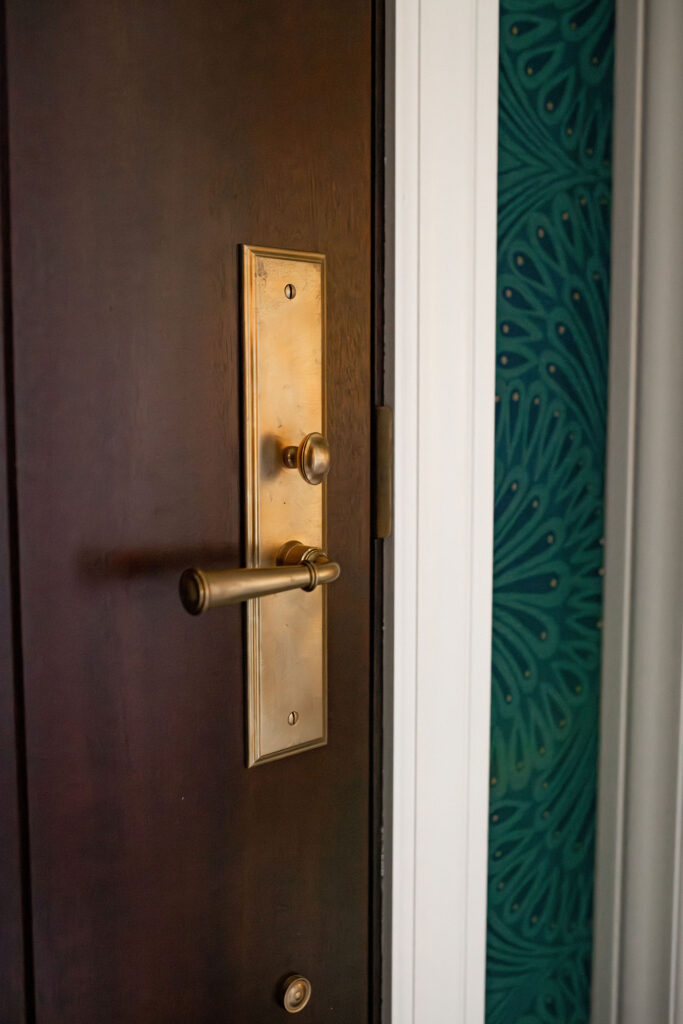 White trim in the vestibule with golden finishes. Shaker Heights Ohio interior design Lindsey Putzier