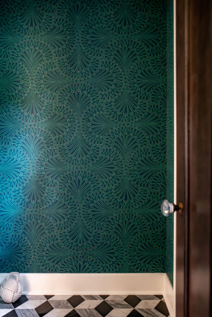 Patterened wallpaper in the vestibule with dark wooden door and tile flooring. Shaker Heights Ohio interior design Lindsey Putzier