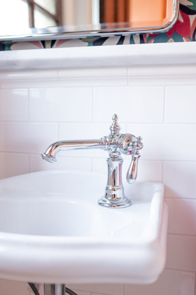 Sink in the powder room with white subway tile and silver faucet. Lindsey Putzier interior design Shaker Heights.
