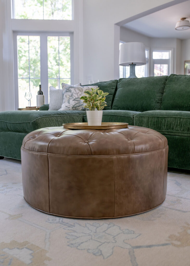 Brown leather ottoman in the living room with creme patterned rug and green couch. Lindsey putzier interior design Chagrin Falls Ohio