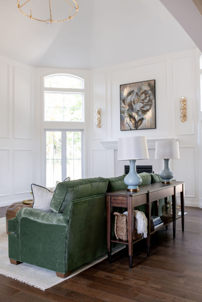 Open concept living room with green  sofa and soft accents. Chagrin Falls Ohio interior design Lindsey Putzier 