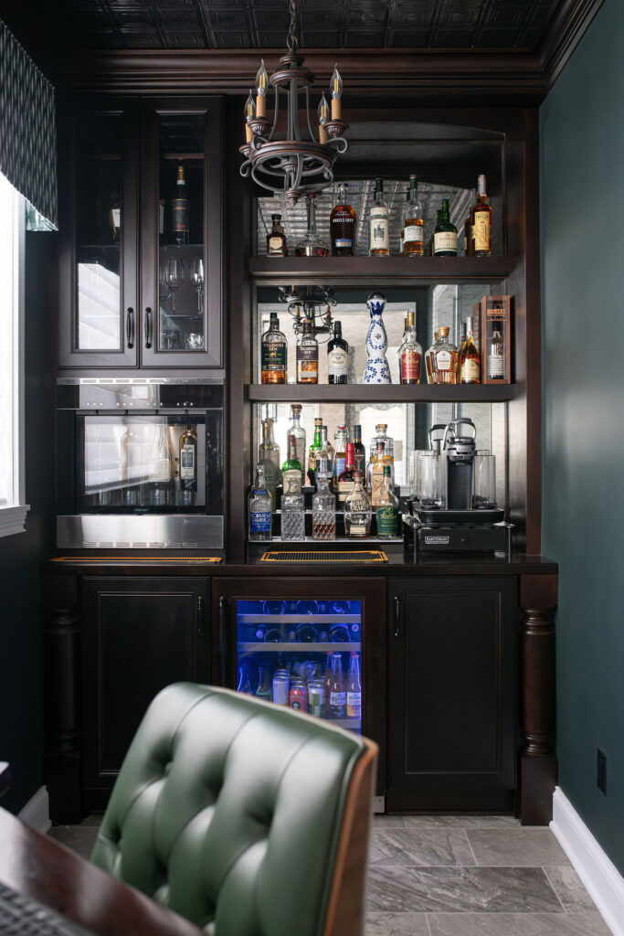 Custom bar area with wine dispenser, mini fridge, and liquor storage. Brecksville Ohio interior design Lindsey Putzier
