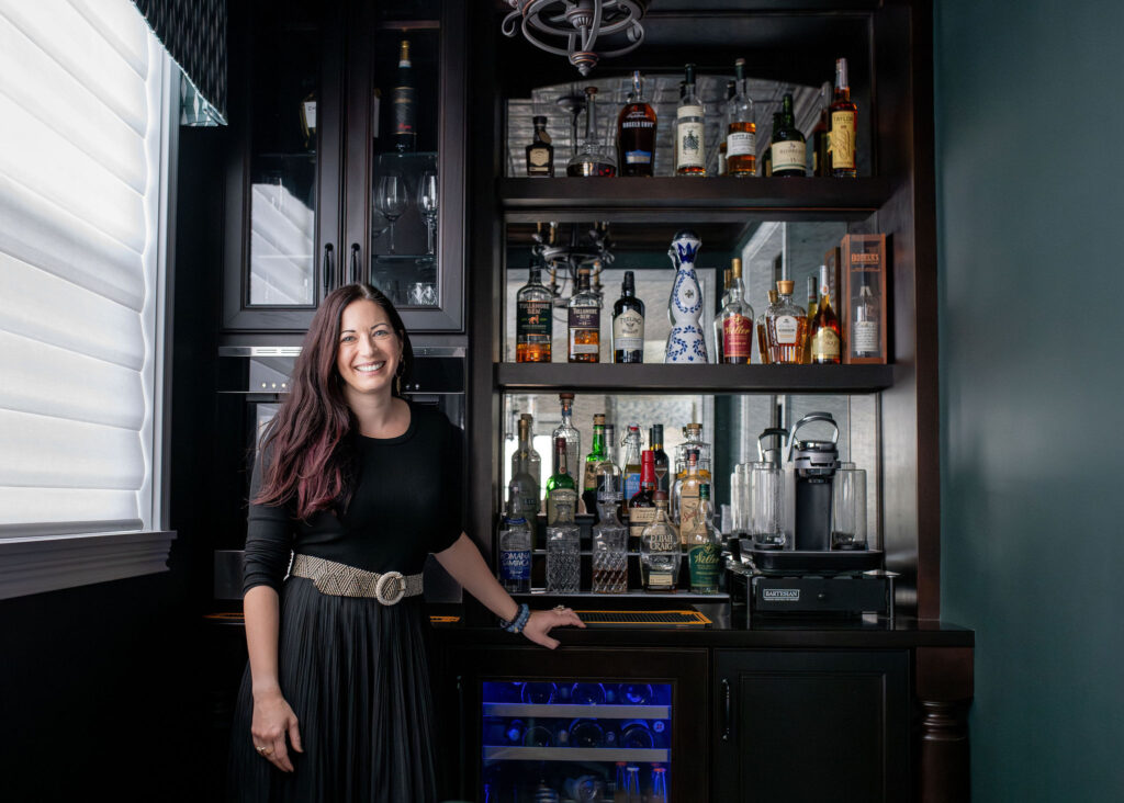 Lindsey Putzier, principal design and founder, standing in the home office and bar area. Brecksville Ohio interior design Lindsey Putzier