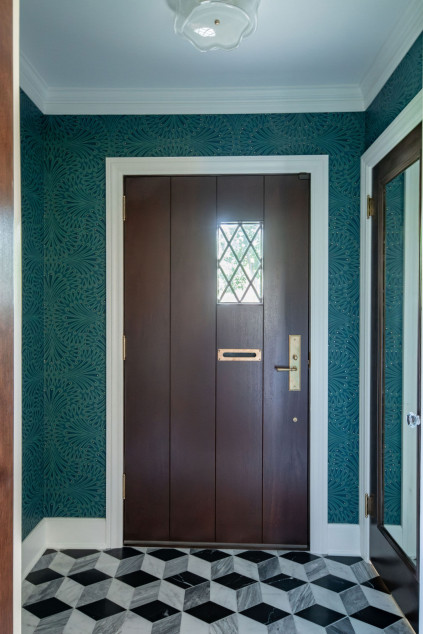Transformed front vestibule with patterned wallpaper and tile flooring. Shaker Heights Ohio interior design Lindsey Putzier