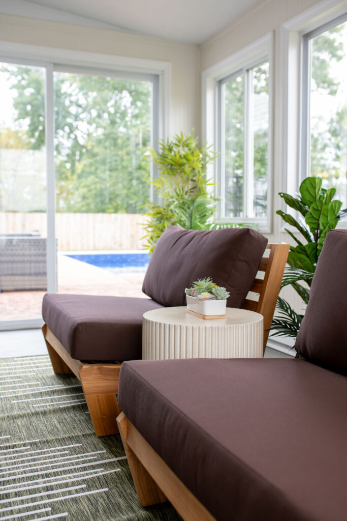 Wooden benches with brown upholstered coverings in the sunroom just off the pool. Lindsey Putzier interior design Parma Ohio Vacation rental