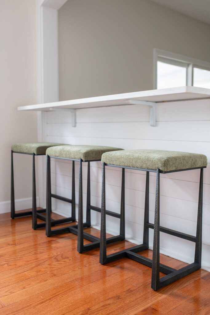 Bar stools as additional seating in between the kitchen and dining room. Parma Ohio interior design Lindsey Putzier