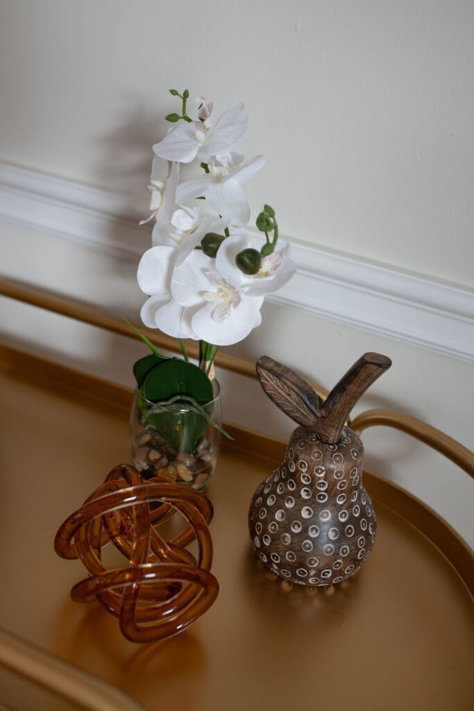 Close up details of the bar cart in the dining room with flowers, and brown accents. Parma Ohio interior design Lindsey Putzier i