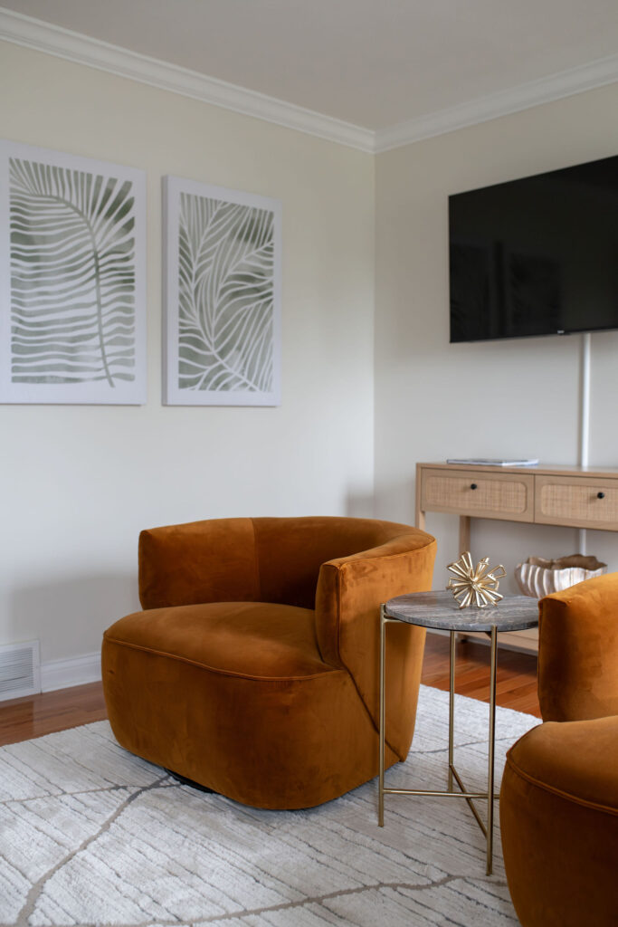 Cozy burnt orange accent chairs in the living room of Parma Vacation Rental. interior design Lindsey Putzier