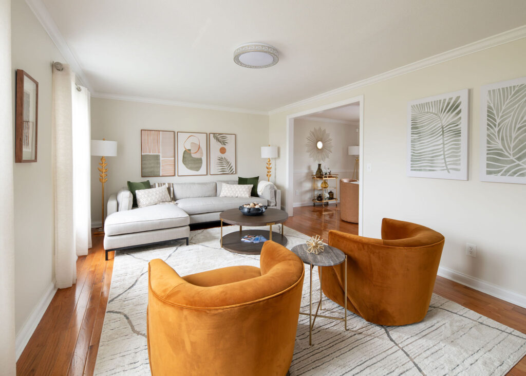 Living room with large sectional, abstract art and colorful accent chairs. Lindsey Putzier interior design Parma Ohio