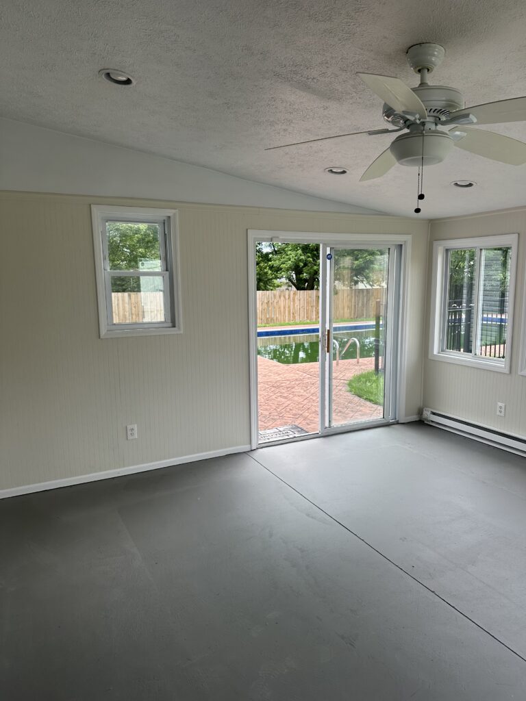 Before of the sunroom in Parma Ohio vacation rental, with concrete flooring, and a pool. Lindsey Putzier interior design.