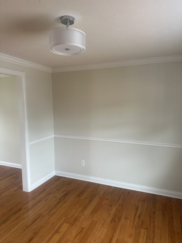 Before of the dining room with hardwood flooring, cream walls, and white trim. Lindsey Putzier interior design Parma Ohio