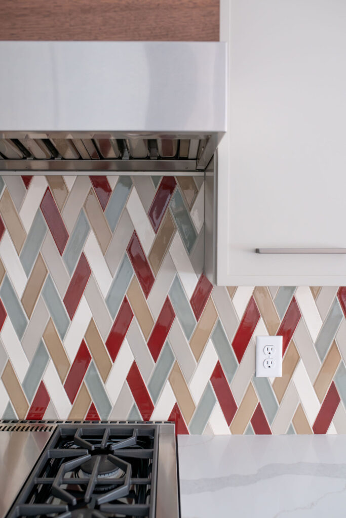 Patterned tile backsplash with pops of color and stone countertops. Lindsey Putzier interior design Chagrin Falls, Ohio