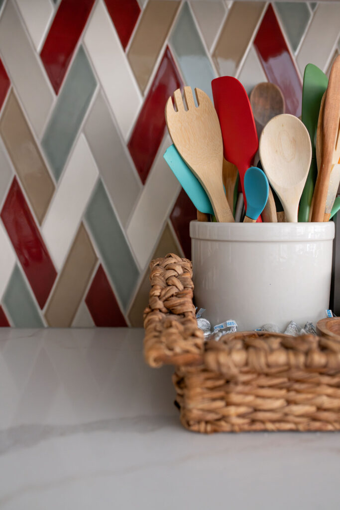 Mosaic backsplash in the kitchen with colorful accents and cooking utensils. Lindsey Putzier interior design Chagrin Falls Ohio. 