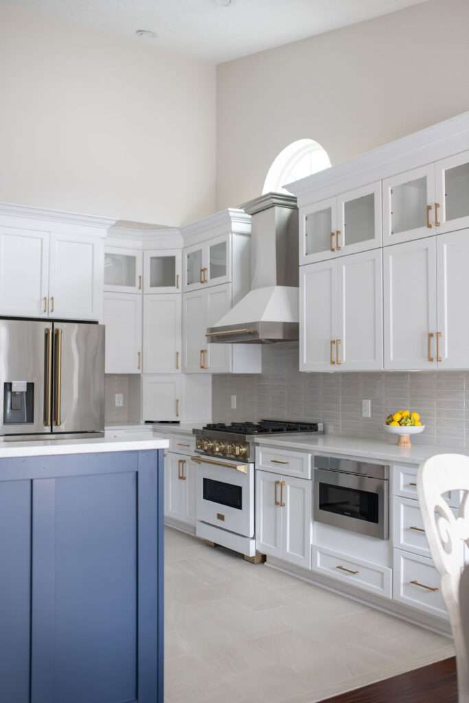 After of kitchen in Peninsula Ohio with Indigo Island, white cabinetry and countertops. Lindsey Putzier interior design 