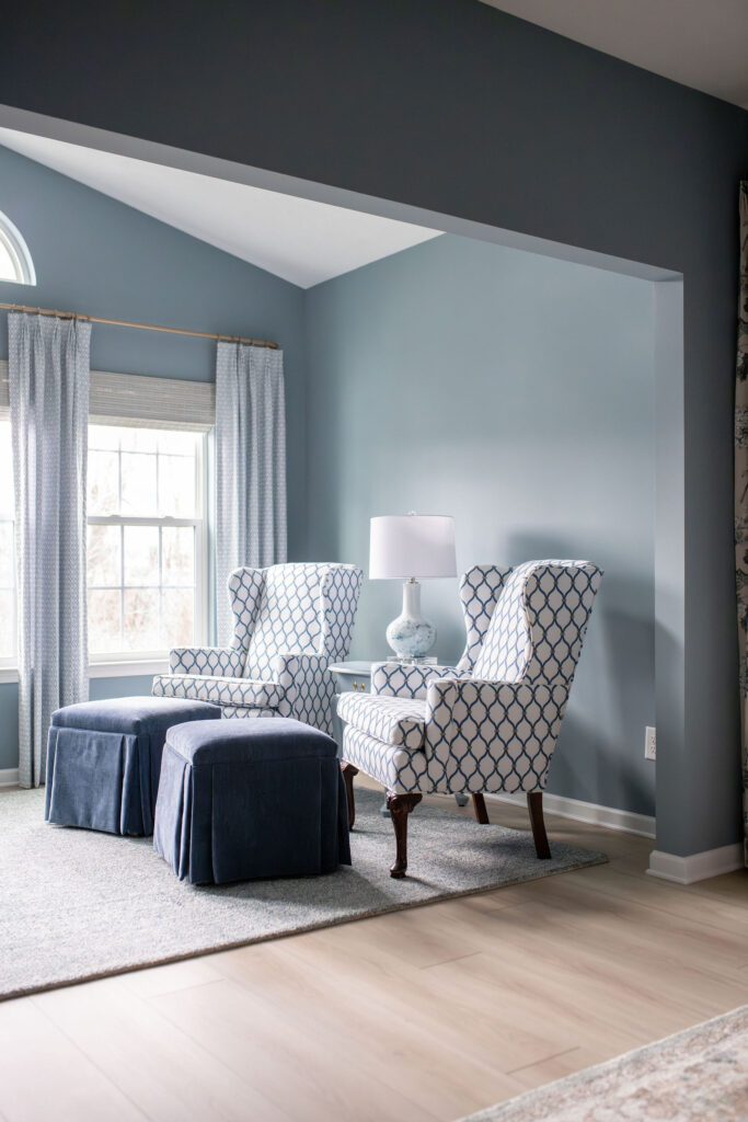 After of the master bedroom with custom reupholstered chairs and footbrests, blue walls, and hardwood flooring. Lindsey Putzier interior design Peninsula Ohio 