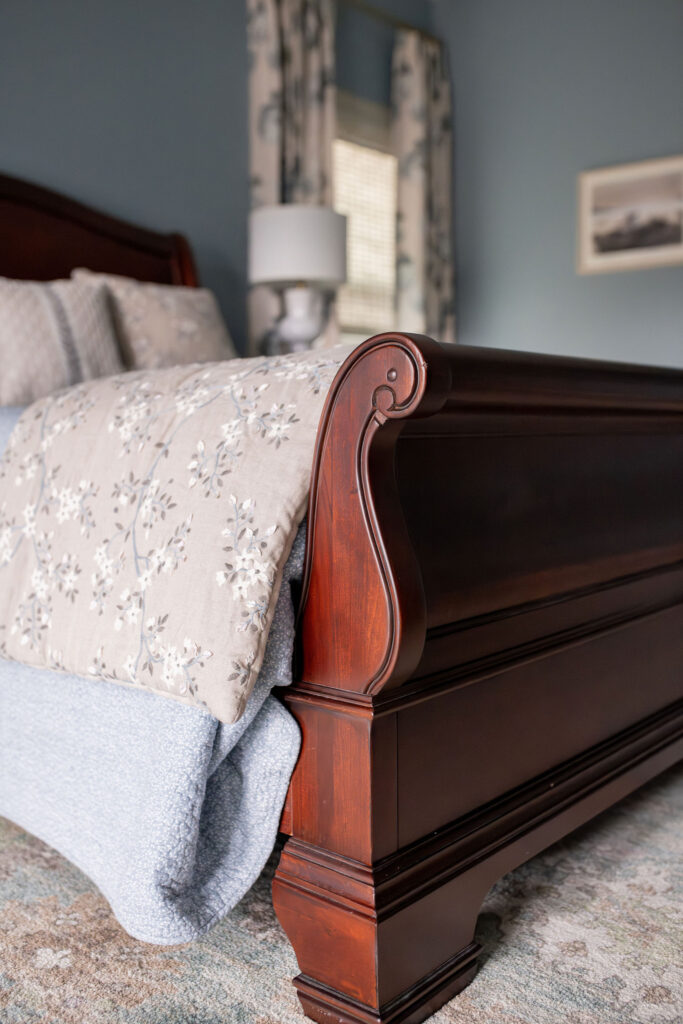 After of the master bedroom with blue colored walls and floral drapes. Lindsey Putzier interior design Peninsula Ohio