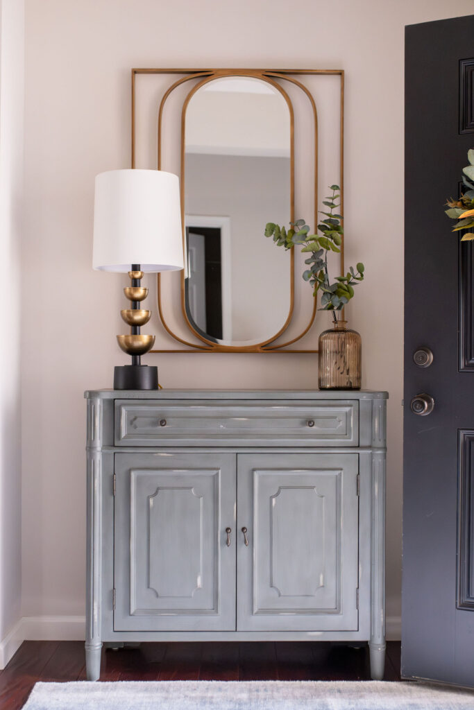 Entryway in Peninsula Ohio home with blue cabinet and golden mirror. Lindsey Putzier interior design