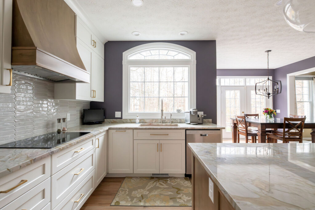 Kitchen remodel with stovetop and custom wooden range, white cabinetry, custom tile countertops and purple accent wall. Lindsey Putzier interior design Aurora Ohio