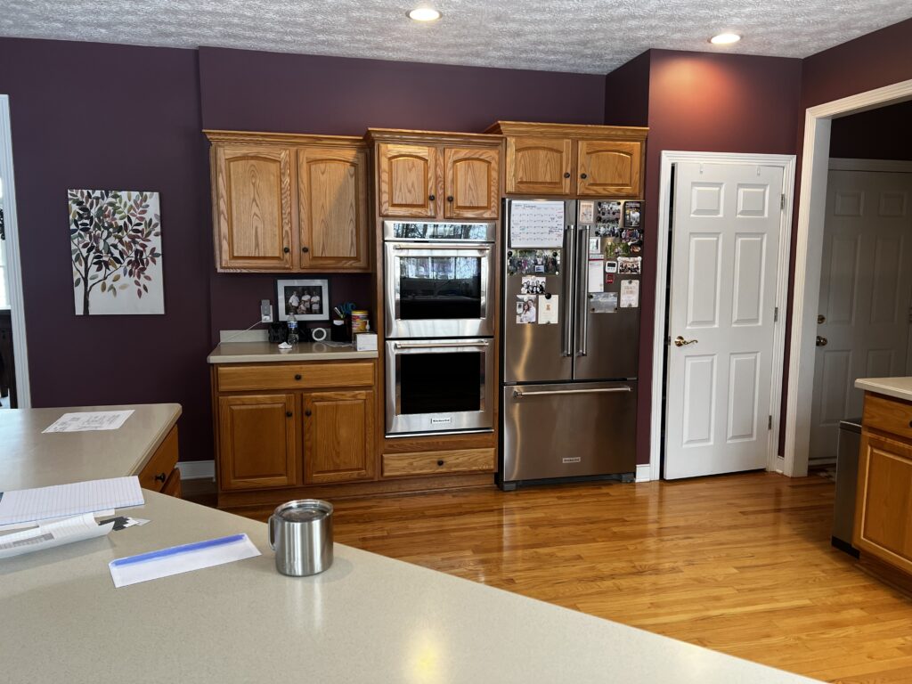 Before of kitchen renovation in Aurora Ohio with warm wooden cabinets and an awkward layout. Lindsey Putzier interior design 