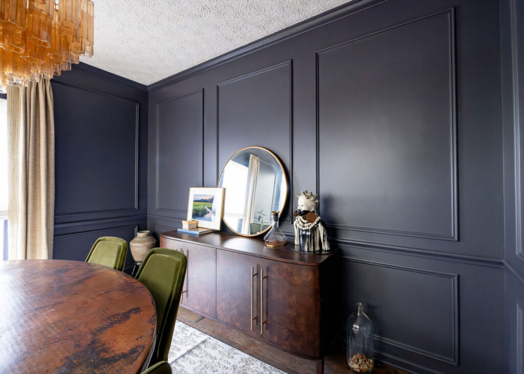 Dining room transformation with dark walls and wainscoting, deep wooden buffet and table with golden accents Copley Ohio Lindsey Putzier interior design 